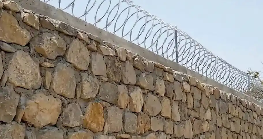 Instalación de concertina de seguridad de acero galvanizado con cuchillas tipo arpón sobre muro perimetral en Neuquén Capital, brindando máxima protección disuasoria en el Alto Valle.